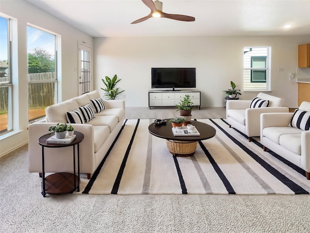 living area with a ceiling fan and plenty of natural light