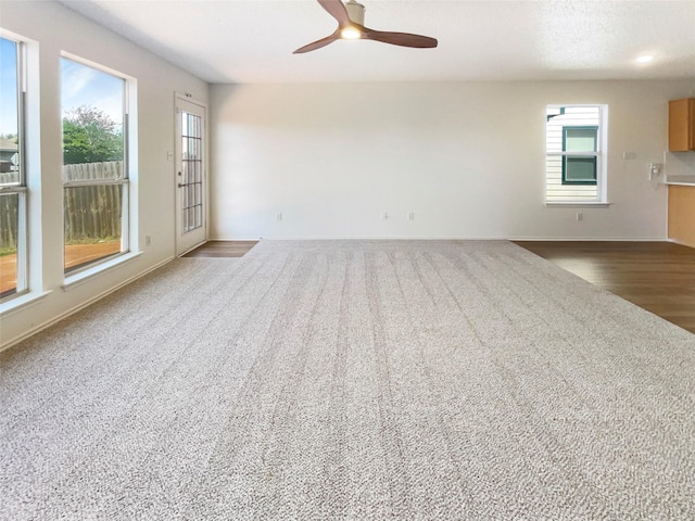 interior space with ceiling fan, baseboards, and a healthy amount of sunlight