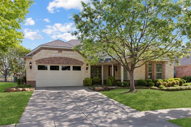 7142 Bay Hill Dr, Frisco, TX 75036 - view of front of home featuring stone siding, brick siding, driveway, a garage, and a front yard