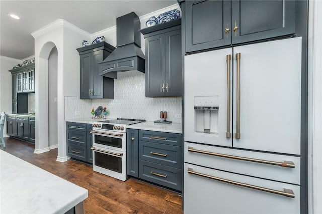 kitchen featuring ornamental molding, tasteful backsplash, high quality appliances, light countertops, and premium range hood