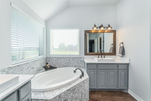 bathroom with two vanities, a sink, lofted ceiling, and plenty of natural light