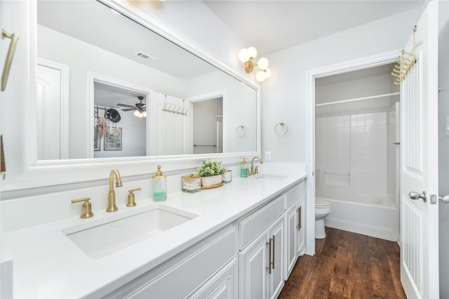 full bath with visible vents, toilet, double vanity, and a sink