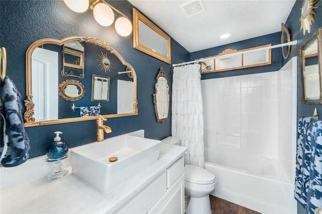 full bathroom with wood finished floors, shower / bath combo, toilet, vanity, and visible vents