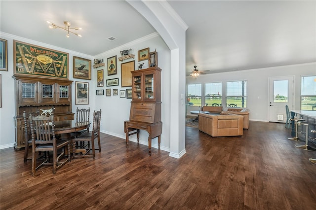 dining area with dark wood-type flooring, arched walkways, a ceiling fan, and crown molding