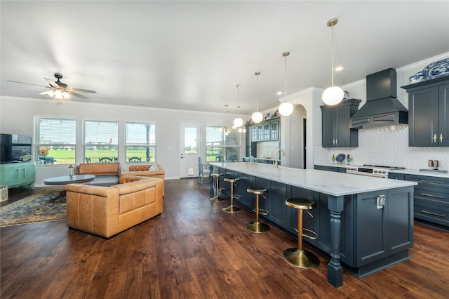 kitchen with custom range hood, a large island, high end range, open floor plan, and crown molding