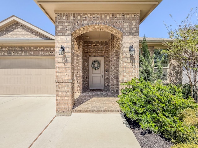 1005 Napier Way, Fort Worth, TX 76247 - view of exterior entry with brick siding, an attached garage, and concrete driveway