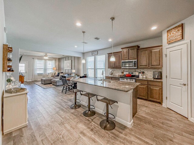 1005 Napier Way, Fort Worth, TX 76247 - kitchen with appliances with stainless steel finishes, open floor plan, a breakfast bar area, plenty of natural light, and recessed lighting