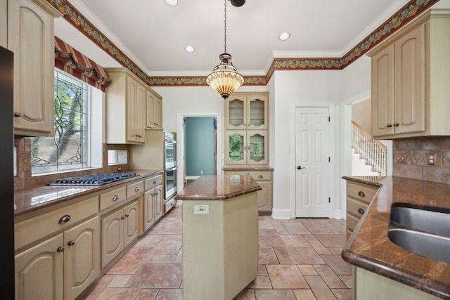 kitchen with a center island, cream cabinets, a wealth of natural light, and stainless steel appliances