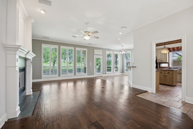 unfurnished living room featuring crown molding, baseboards, a ceiling fan, and a high end fireplace