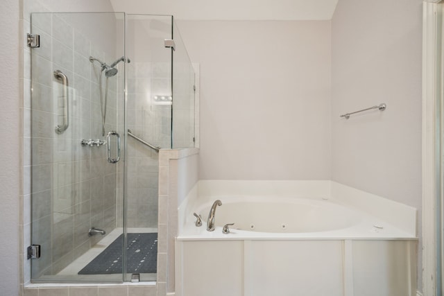 bathroom featuring a stall shower and a tub with jets