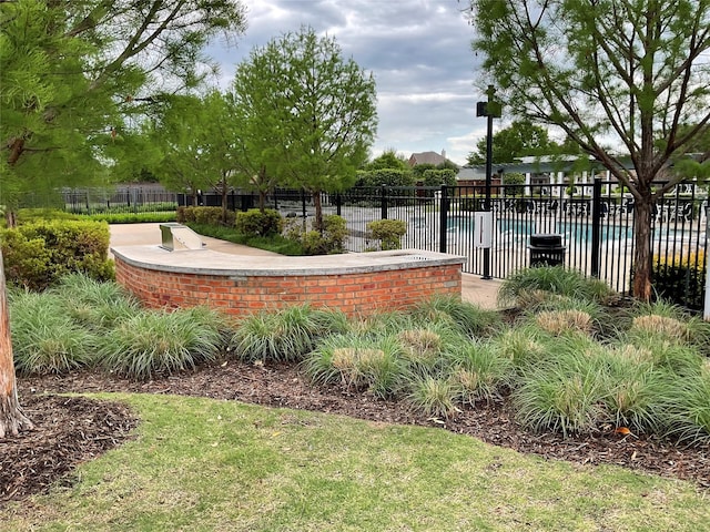 view of property's community with a pool and fence