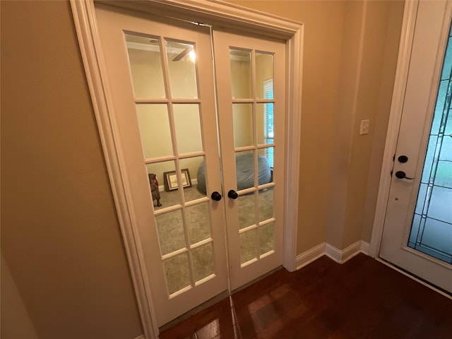 doorway featuring baseboards, french doors, and dark wood-style floors