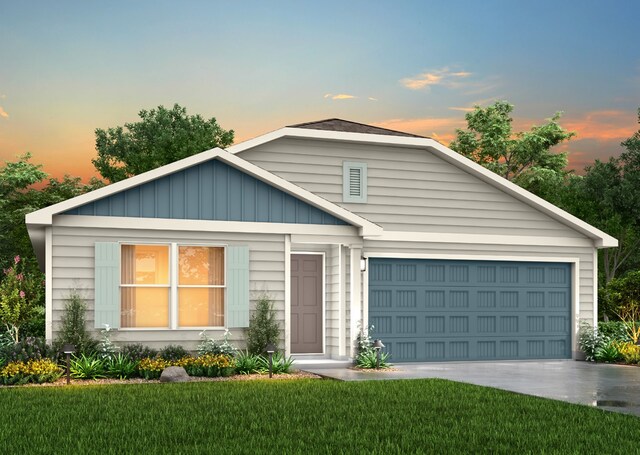 view of front of property featuring a front yard, driveway, and an attached garage
