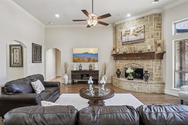 1011 Caribou Dr, Prosper, TX 75078 - living area featuring arched walkways, crown molding, a ceiling fan, wood finished floors, and a fireplace