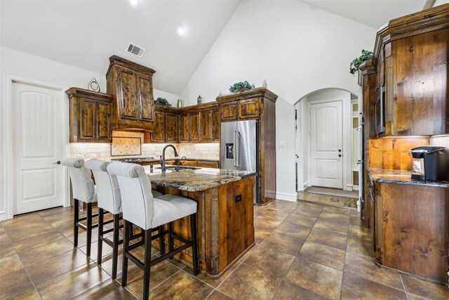 1011 Caribou Dr, Prosper, TX 75078 - kitchen featuring high end refrigerator, a sink, backsplash, vaulted ceiling, and light stone counters
