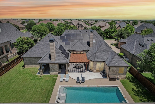 1011 Caribou Dr, Prosper, TX 75078 - back of property at dusk with brick siding, a fenced backyard, and roof with shingles