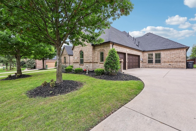 1011 Caribou Dr, Prosper, TX 75078 - french country style house featuring brick siding, an attached garage, a front lawn, a shingled roof, and driveway