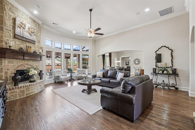 1011 Caribou Dr, Prosper, TX 75078 - living area with arched walkways, ceiling fan, a fireplace, crown molding, and dark wood-style floors