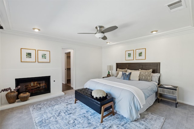 carpeted bedroom with ceiling fan, a glass covered fireplace, ornamental molding, visible vents, and recessed lighting