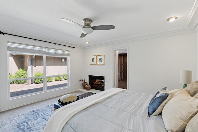bedroom featuring a lit fireplace, a ceiling fan, ornamental molding, and carpet