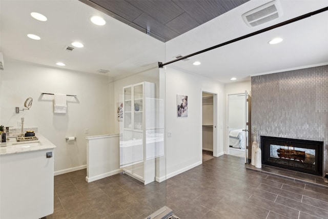 bathroom featuring a multi sided fireplace, tile patterned flooring, visible vents, recessed lighting, and baseboards