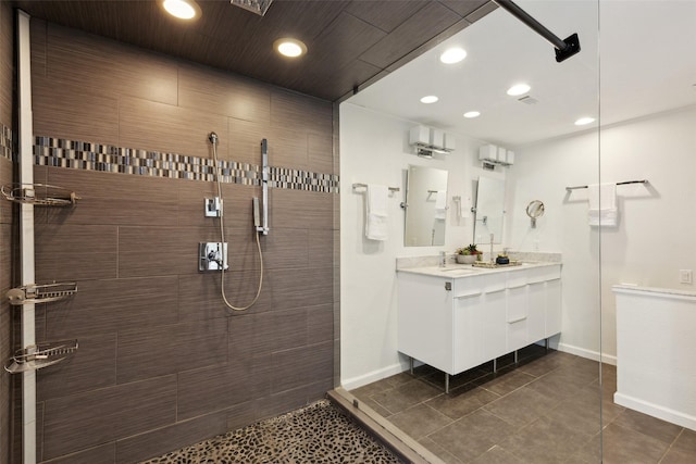 full bath featuring baseboards, a walk in shower, vanity, and recessed lighting