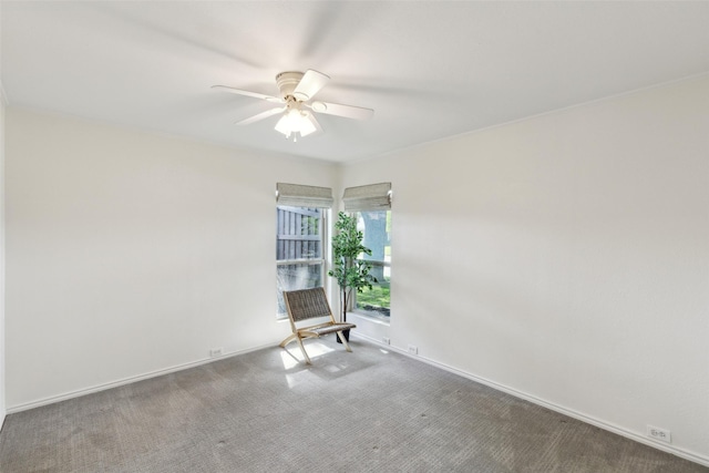 carpeted empty room featuring baseboards and a ceiling fan