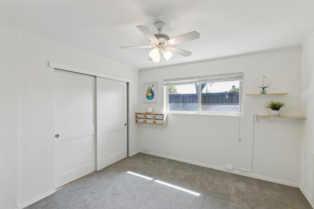 unfurnished bedroom featuring carpet, a closet, baseboards, and ceiling fan
