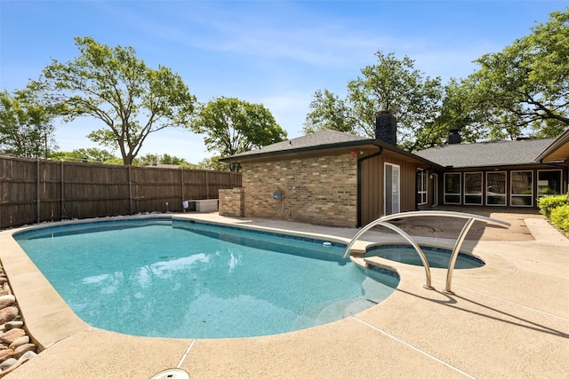 view of pool featuring a patio, a pool with connected hot tub, and fence