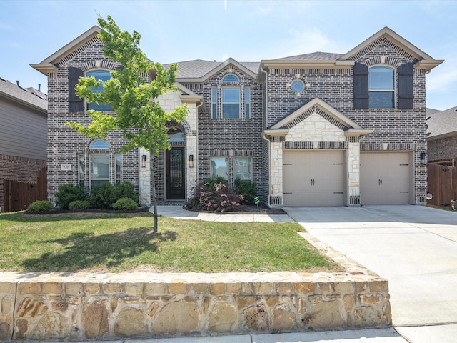 traditional home featuring a front yard, stone siding, a garage, brick siding, and driveway