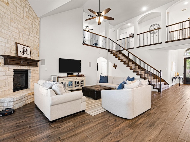 living room with dark wood-style floors, high vaulted ceiling, a ceiling fan, and stairs