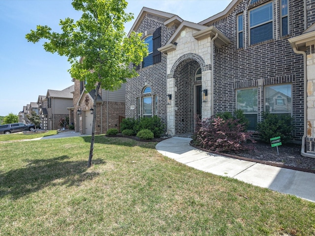 view of front of home with a front yard, brick siding, and stone siding
