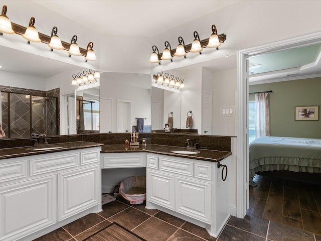 full bath featuring a sink, a shower stall, and double vanity
