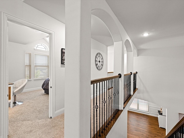 hall featuring baseboards and an upstairs landing