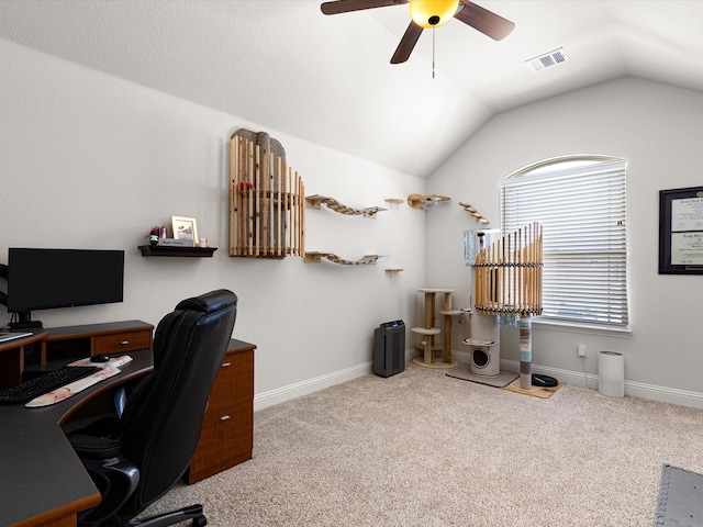 office space featuring lofted ceiling, a ceiling fan, visible vents, and carpet floors