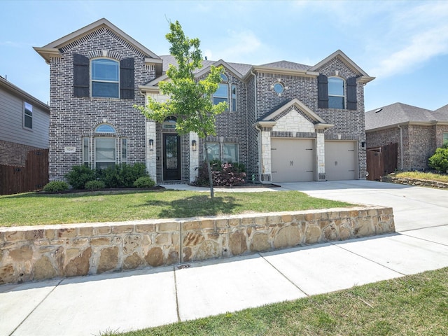 traditional-style house featuring a garage, fence, a front lawn, brick siding, and concrete driveway