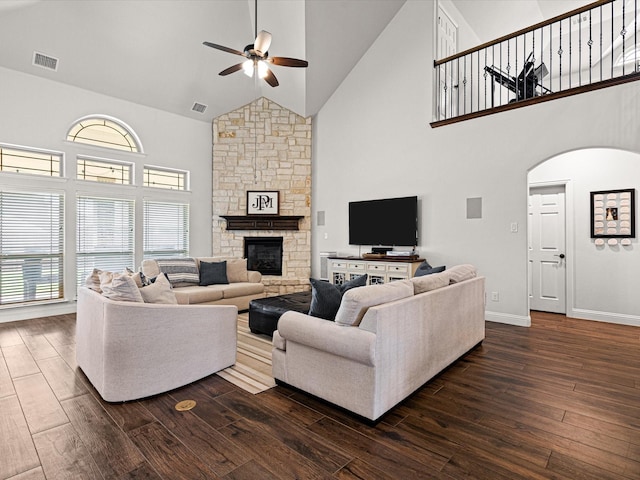 living room with dark wood-type flooring, visible vents, ceiling fan, and high vaulted ceiling