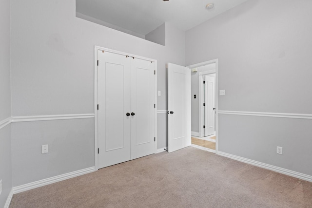 unfurnished bedroom with a closet, carpet flooring, and baseboards