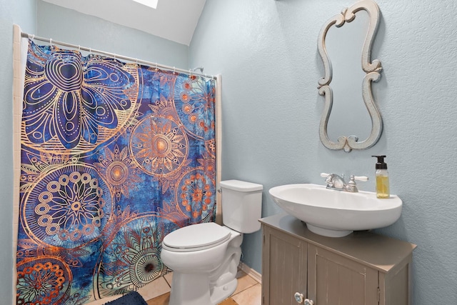bathroom featuring vanity, toilet, baseboards, a shower with shower curtain, and tile patterned floors