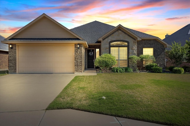 ranch-style home featuring roof with shingles, stone siding, a front lawn, an attached garage, and concrete driveway