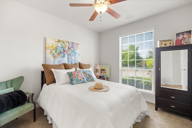 bedroom featuring light carpet, ceiling fan, multiple windows, and visible vents