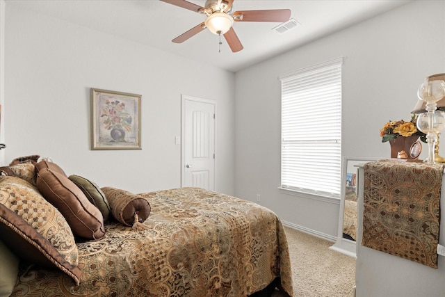 carpeted bedroom with visible vents, baseboards, multiple windows, and a ceiling fan