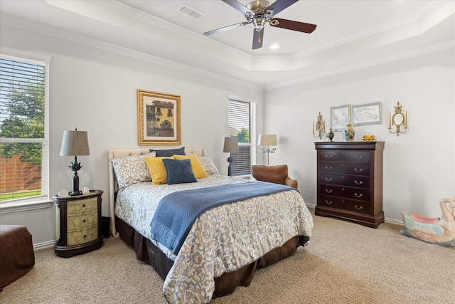 carpeted bedroom with baseboards, crown molding, a ceiling fan, visible vents, and a raised ceiling