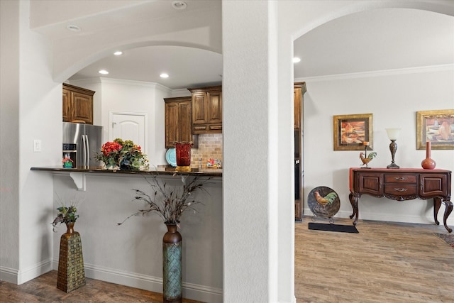 hall with recessed lighting, arched walkways, crown molding, and wood finished floors