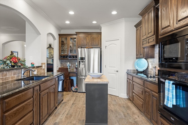 kitchen featuring a sink, tasteful backsplash, black appliances, and crown molding