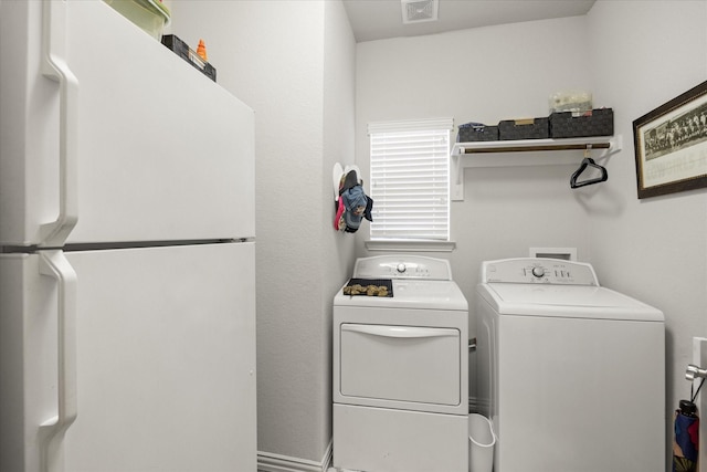 laundry room with laundry area, washing machine and dryer, and visible vents