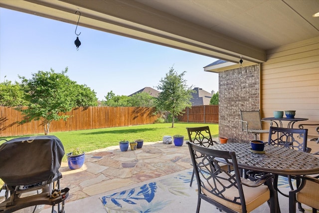 view of patio with a fenced backyard, outdoor dining space, and a grill