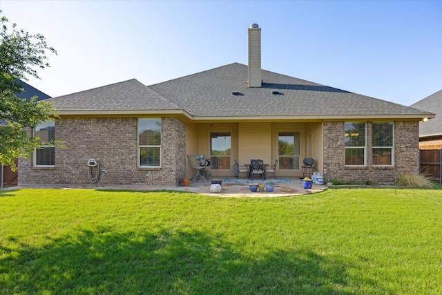 rear view of property with a patio, brick siding, and a lawn