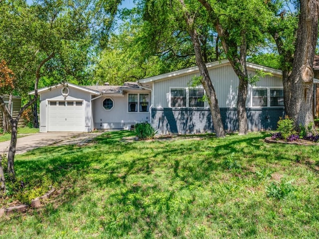 single story home featuring a front yard, an attached garage, and concrete driveway