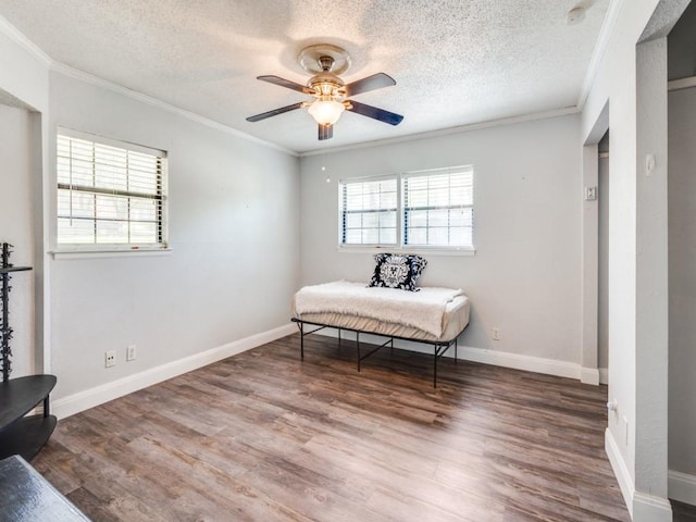 bedroom featuring a textured ceiling, wood finished floors, ceiling fan, and ornamental molding
